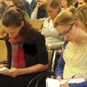 Young researchers taking notes at an event